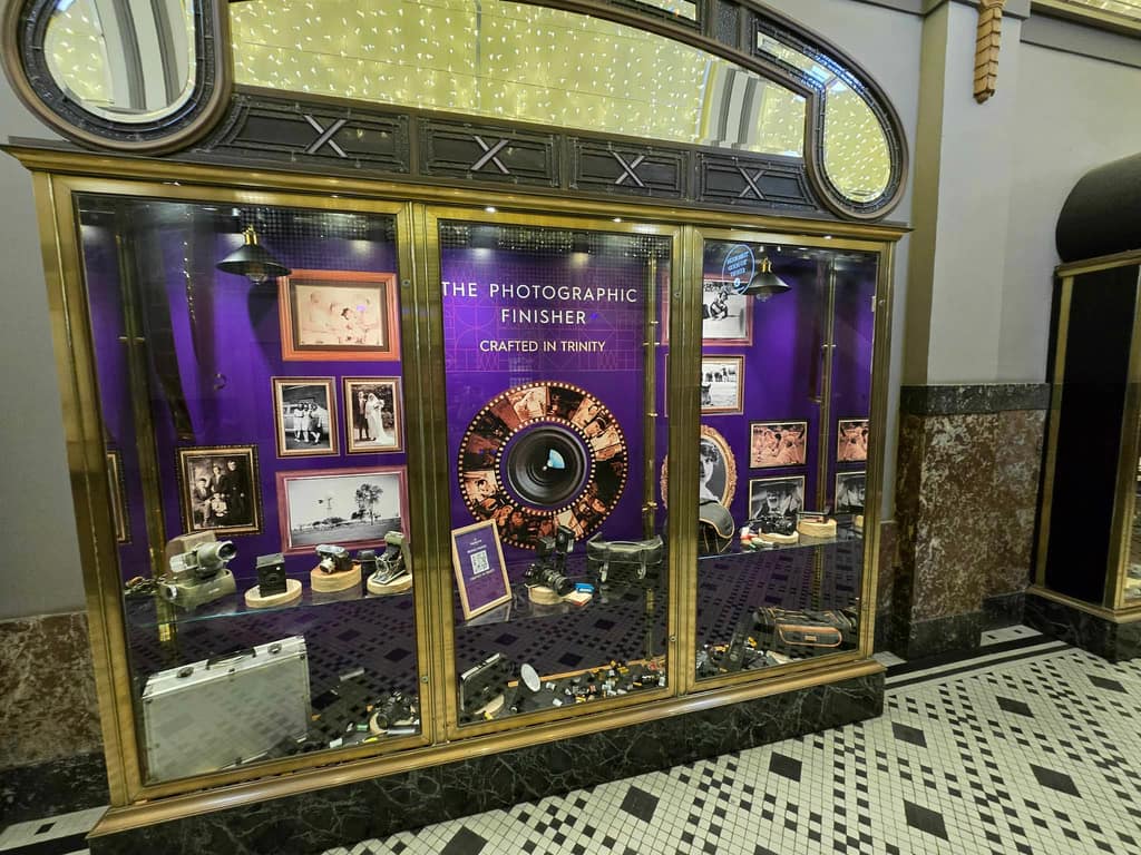 Photographic Finisher installation featuring vintage cameras and framed portraiture