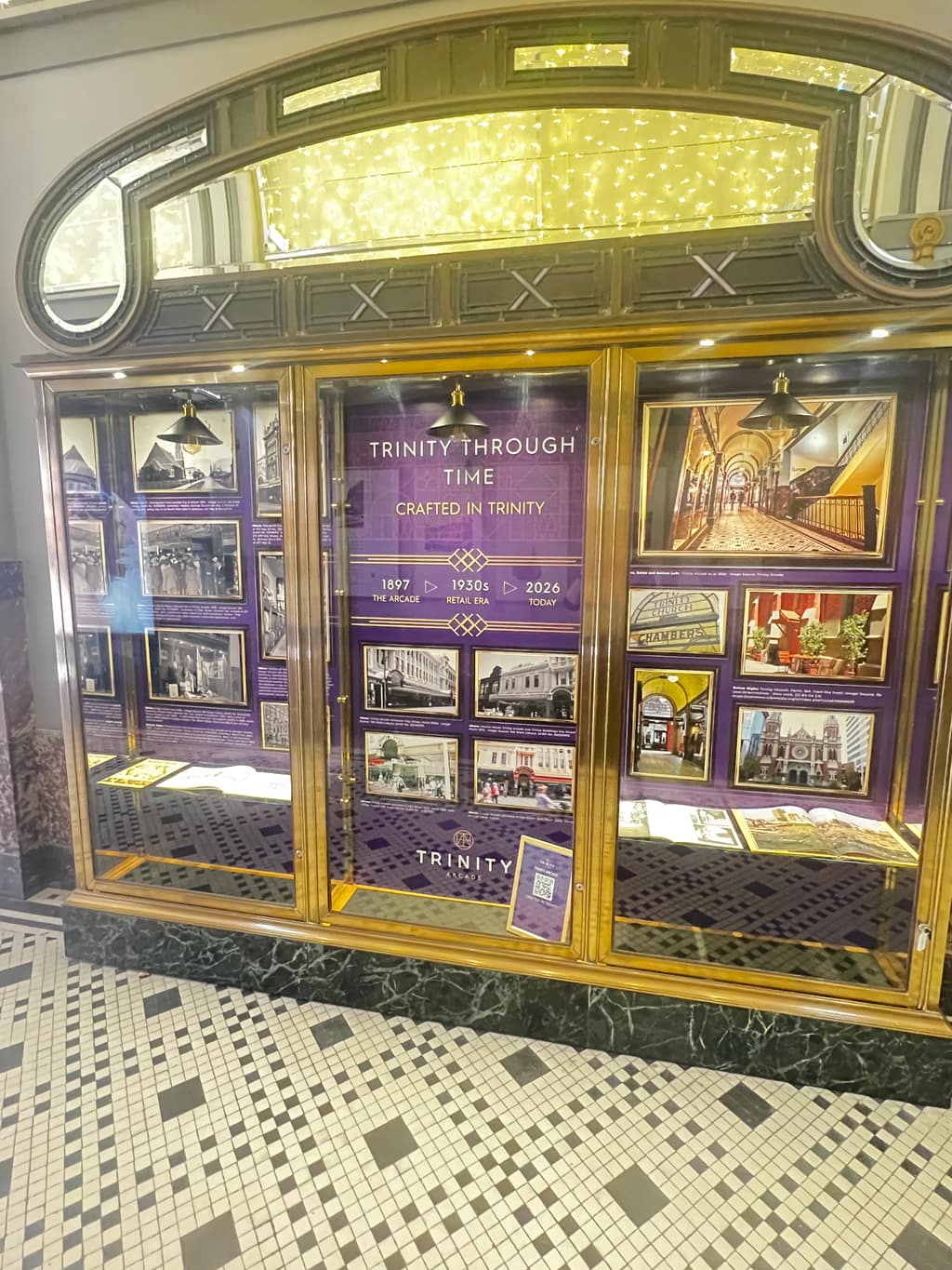 Open Trinity Through Time cabinet during installation showing historical research and layered content