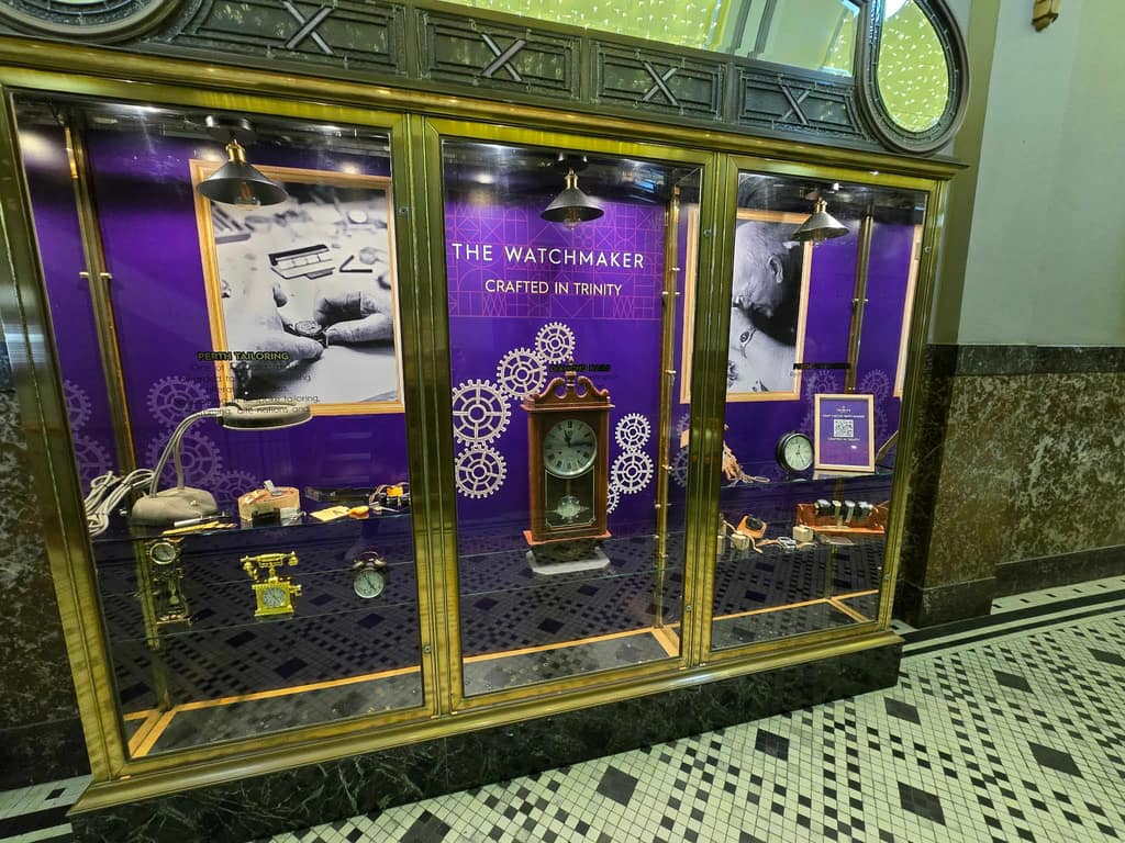 Watchmaker installation in Trinity Arcade with clocks, artefacts, and narrative graphics